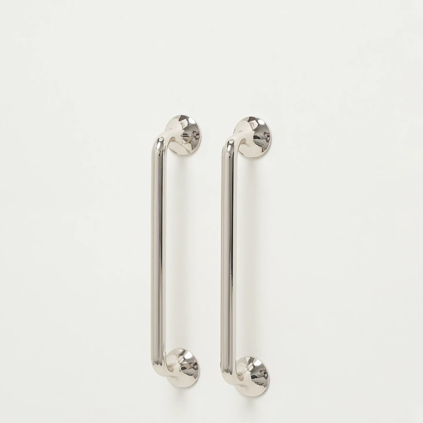 Pair of shiny silver kitchen cupboard round d handles on a white background