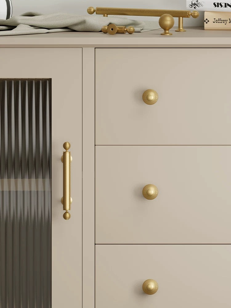 Beige cabinet with gold handles and knobs