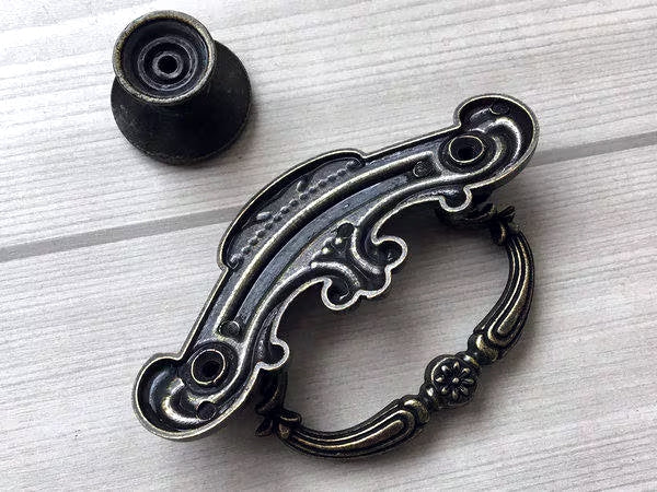 Decorative metal drawer pull on a light wooden surface