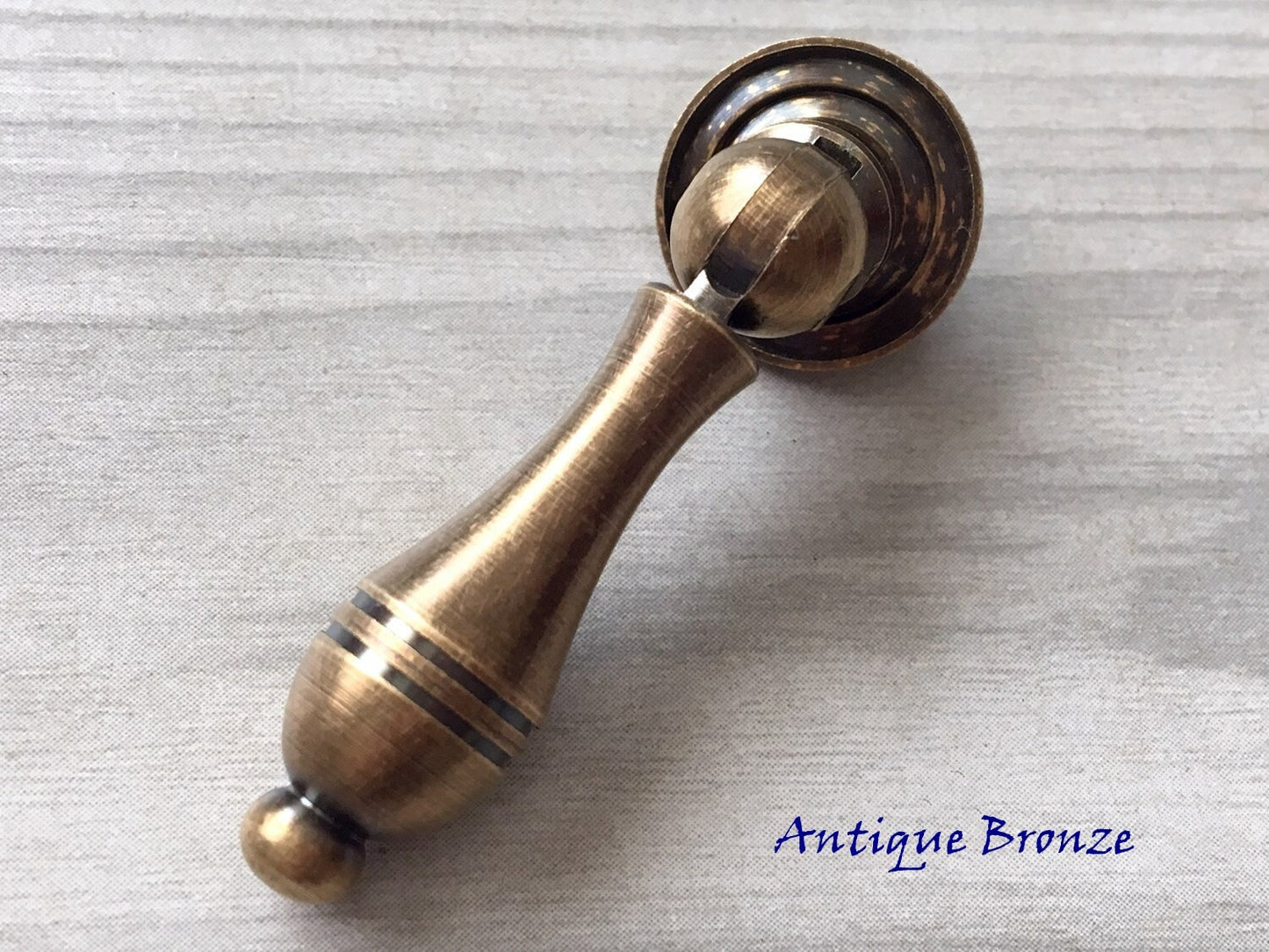 rustic Antique bronze pendant door handle on a textured gray background