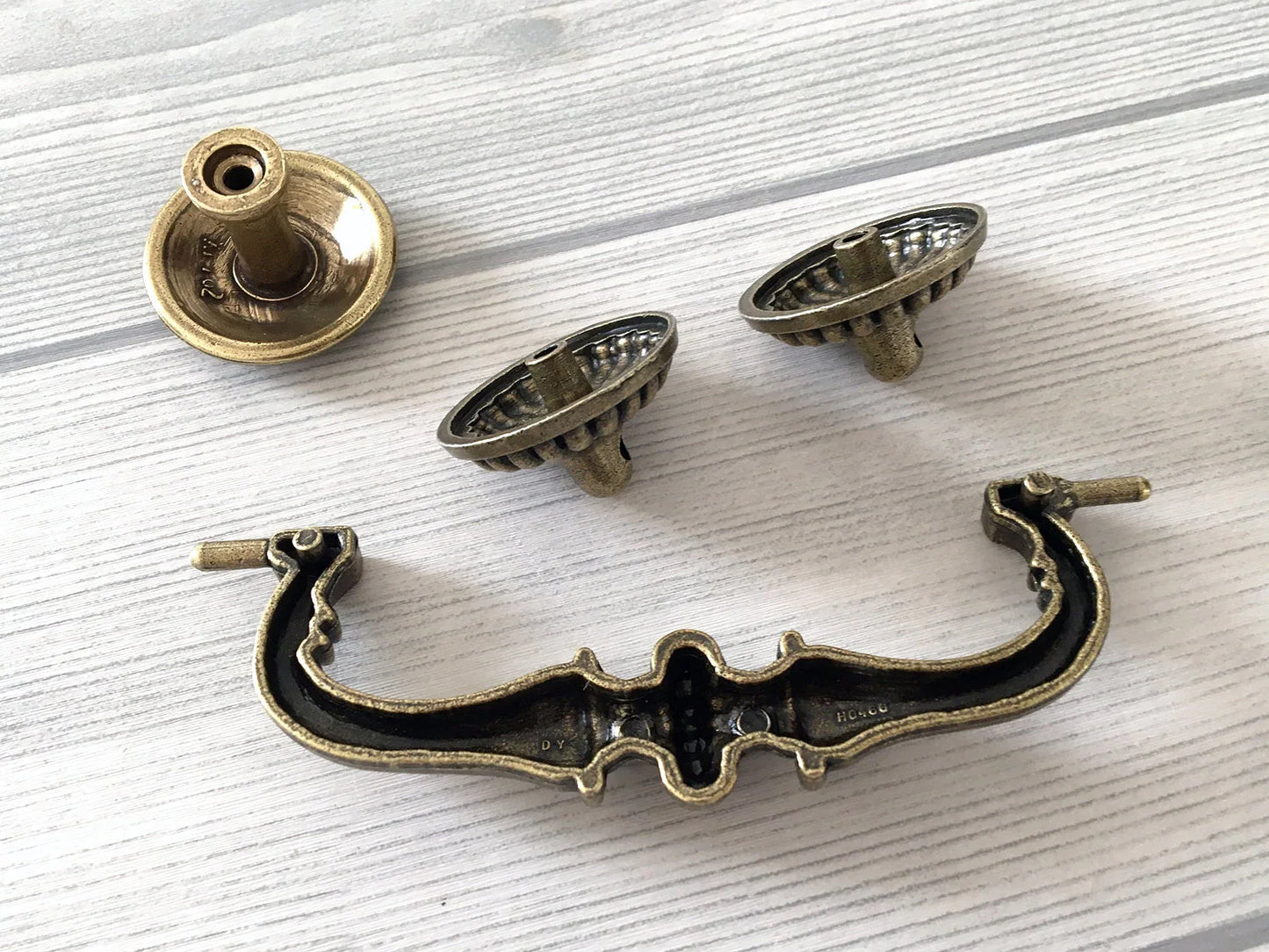 Set of vintage-style metal handles on a light wooden surface