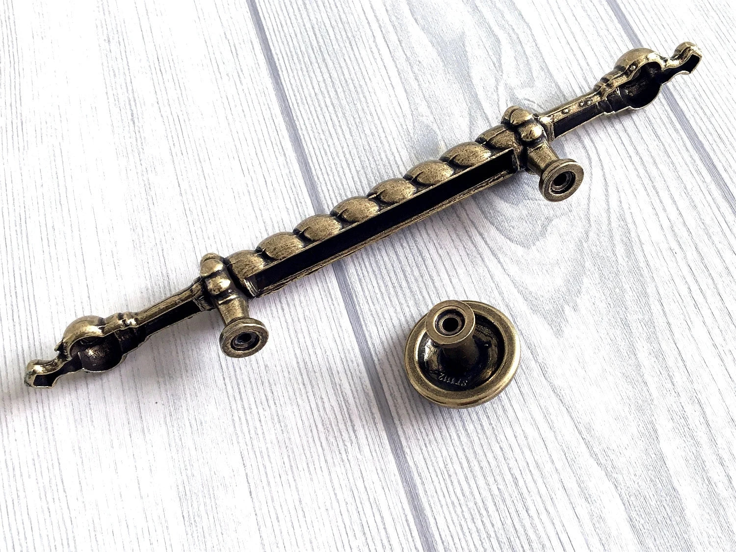 Decorative metal handle on a white wooden surface