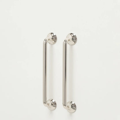 Pair of shiny silver kitchen cupboard round d handles on a white background