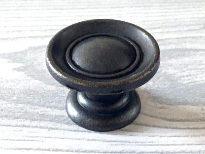 Antique bronze cabinet knob on a light wood surface