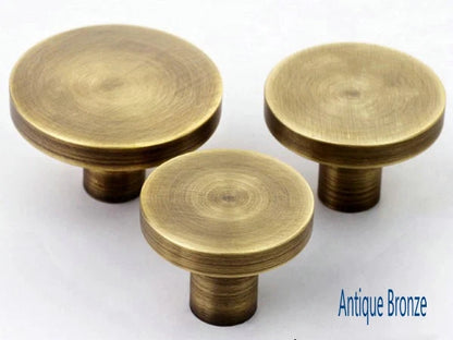 Three antique bronze cabinet circle knobs on a white background