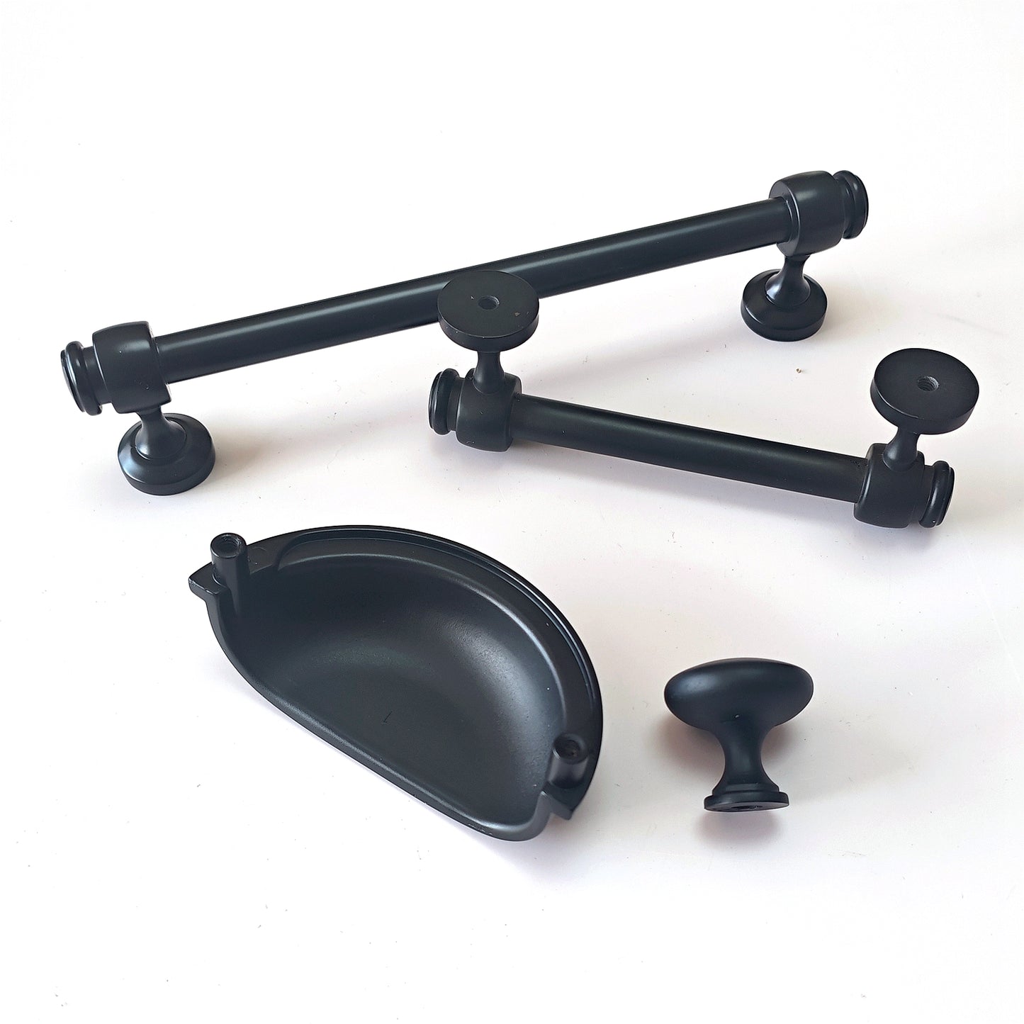 Set of black cabinet handles and knobs on a white background