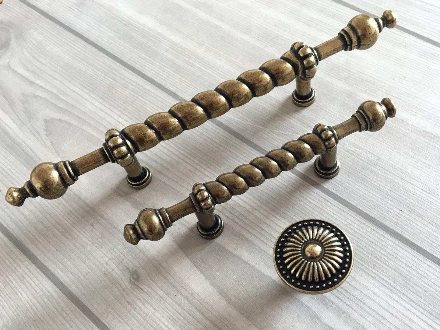 Decorative brass antique bronze cabinet handles on a light wooden surface
