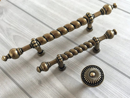 Decorative brass antique bronze cabinet handles on a light wooden surface