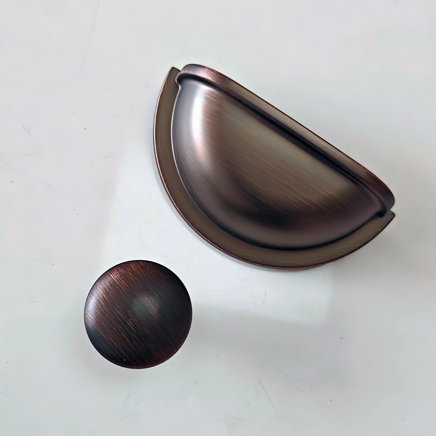 oil rubbed Bronze cabinet cup pull and knob on a white background