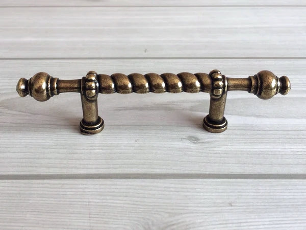 Bronze cabinet handle on a light wood background