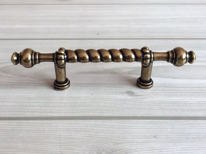 Bronze cabinet handle on a light wood background