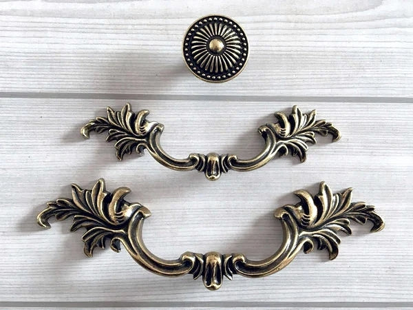 Decorative brass cabinet handles on a white background