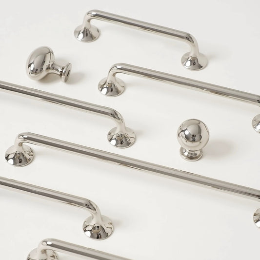 Set of polished silver cabinet d shaped handles and knobs on a white background