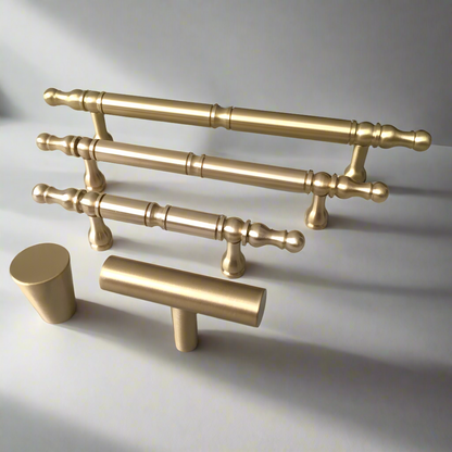 Set of gold cabinet handles on a light gray background