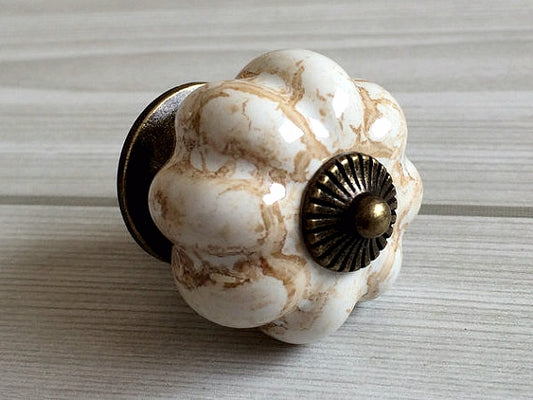 Decorative ceramic door knob with a marble-like pattern on a neutral background