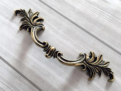 Decorative brass pull handle on a white background