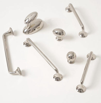 Collection of polished nickel cabinet handles and knobs on a white background