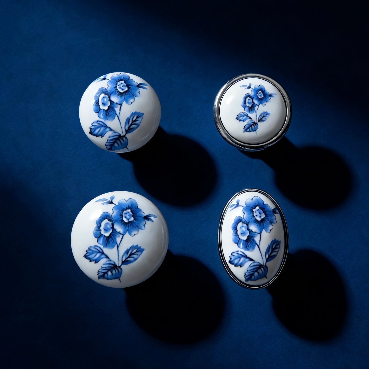 Four ceramic knobs with blue floral patterns on a dark blue background