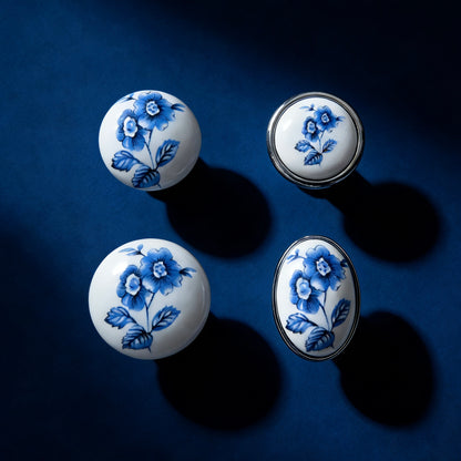 Four ceramic knobs with blue floral patterns on a dark blue background