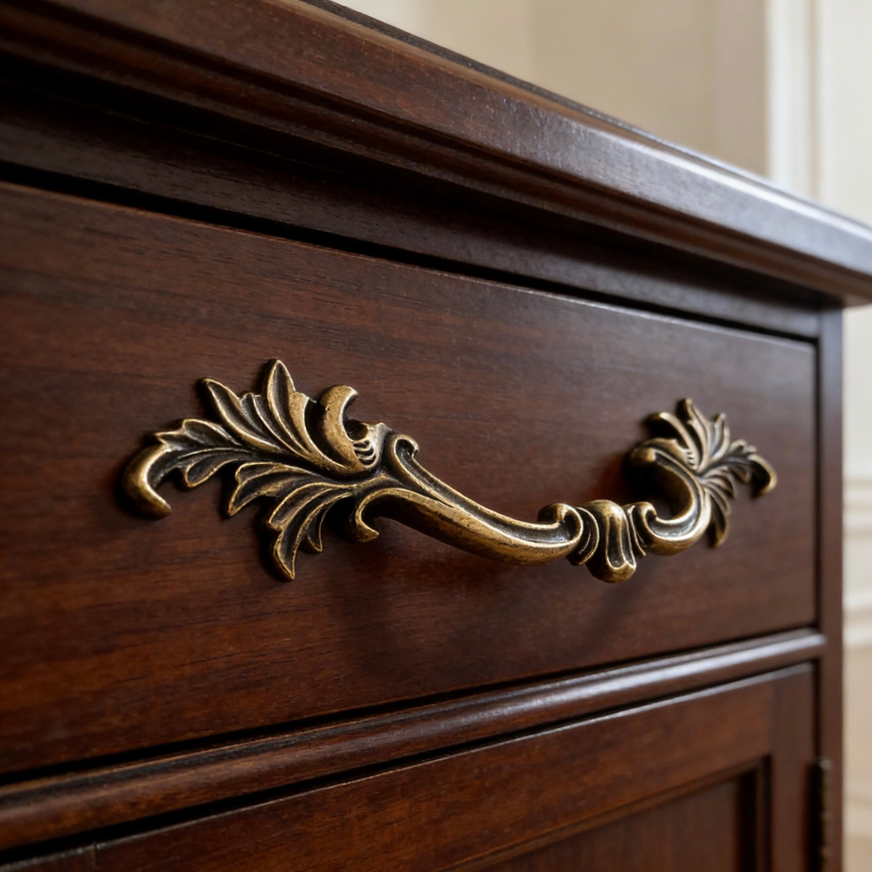 Close-up of a wooden drawer with an ornate brass handle.