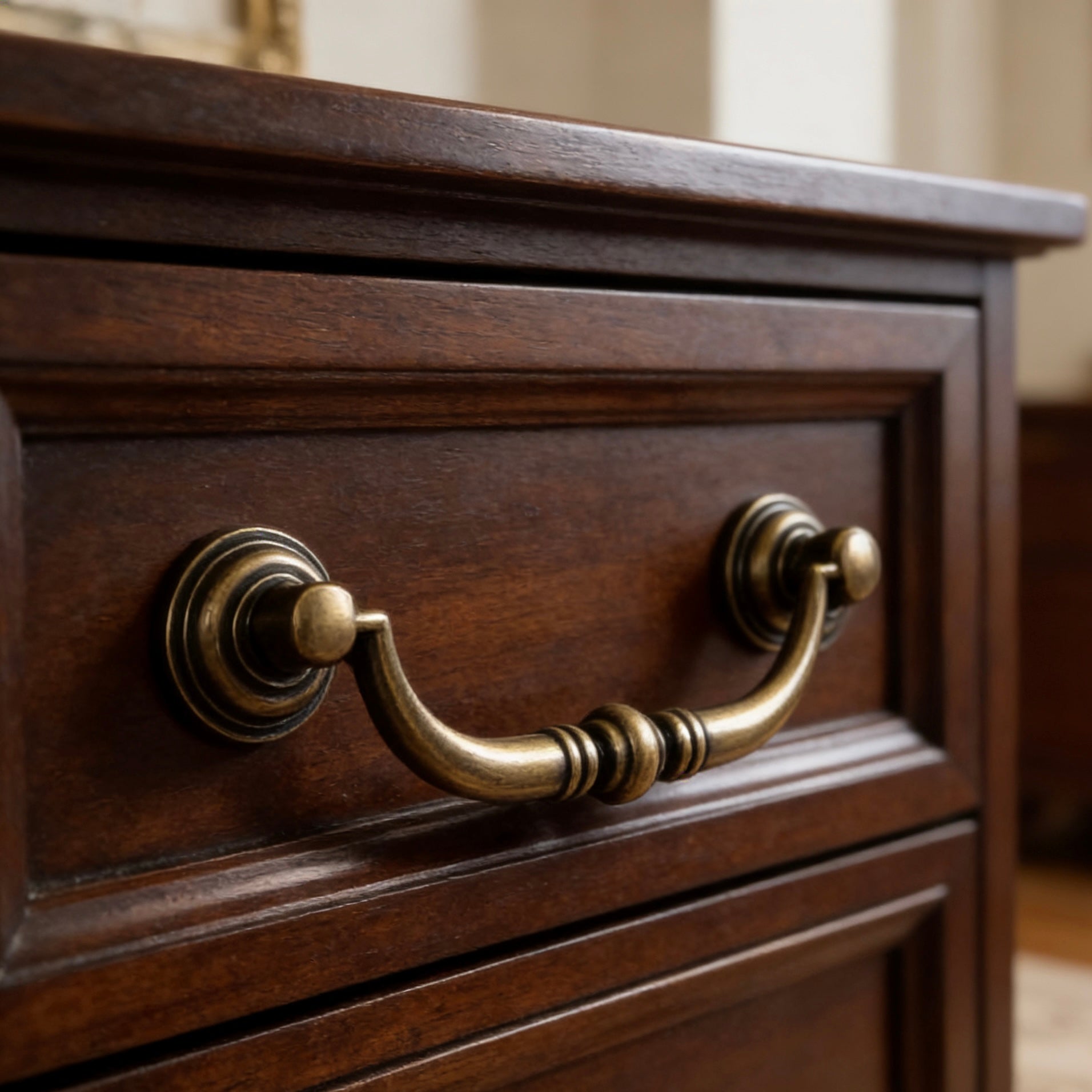 Close-up of a wooden drawer with antique bronze swing bail handle