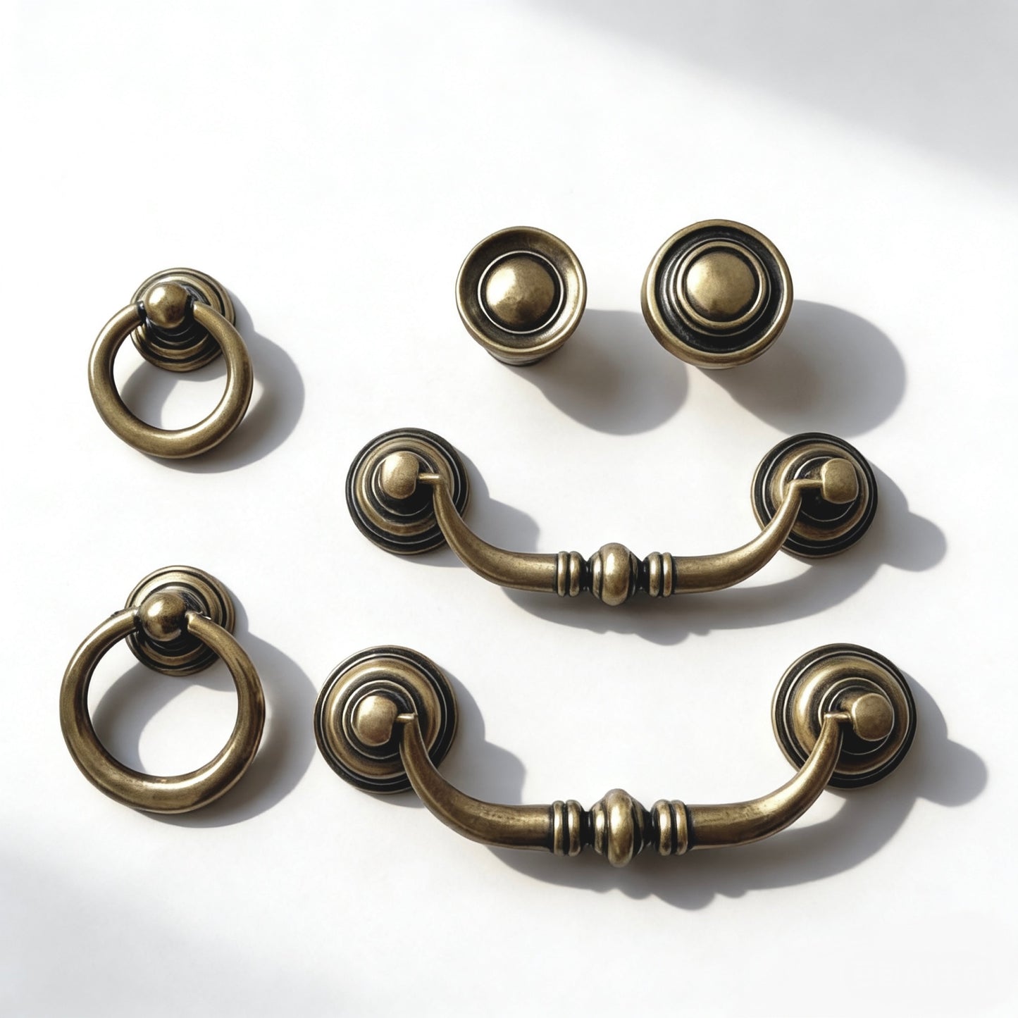 Set of vintage-style antique bronze cabinet handles on a white background