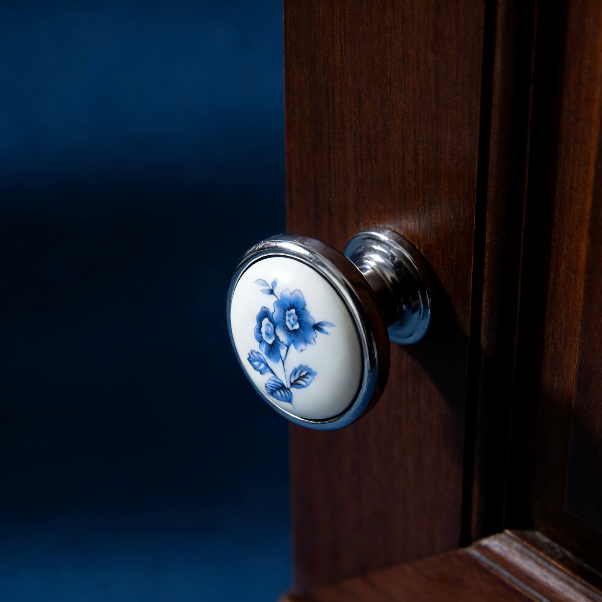ceramic Door handle with floral design on a wooden door
