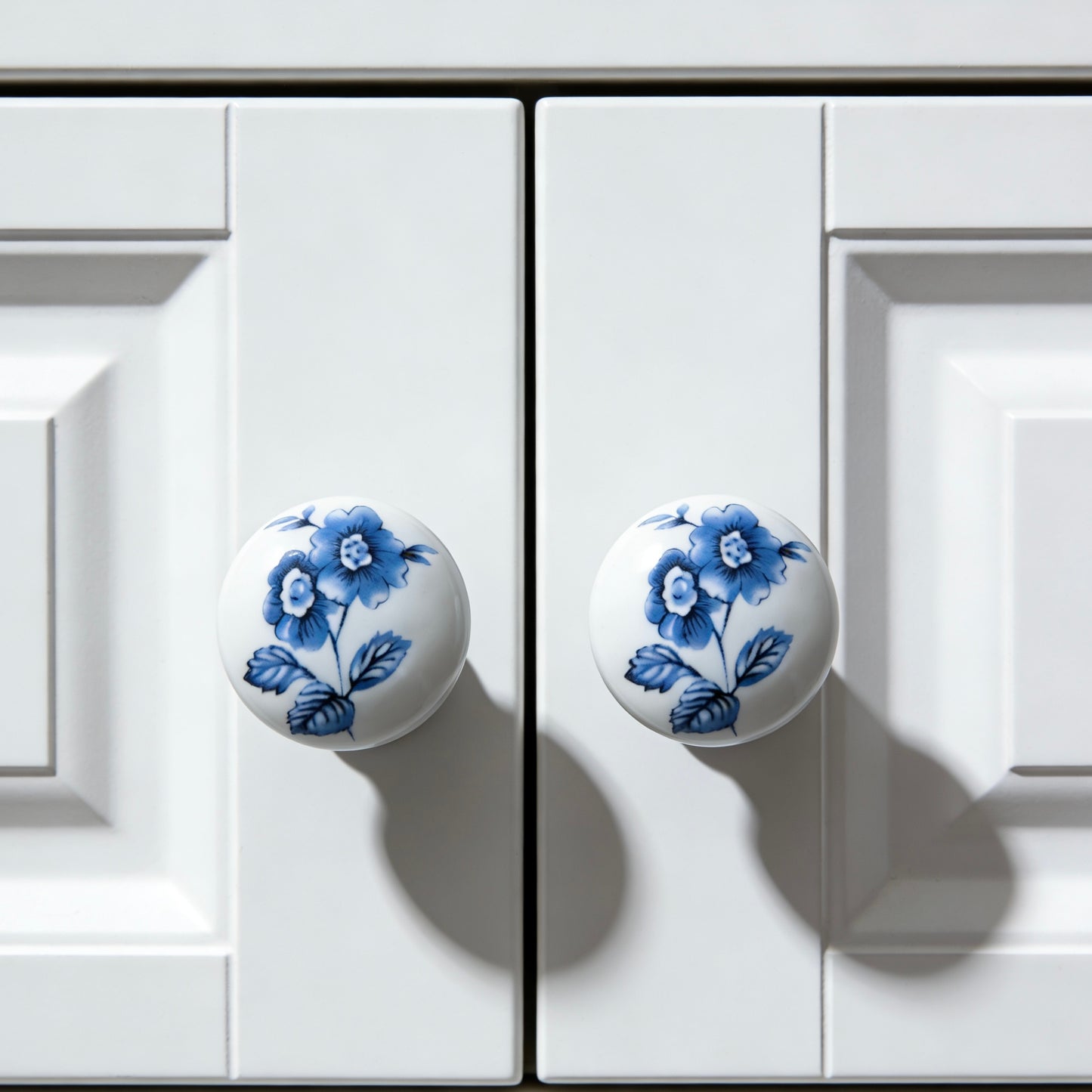 White cabinet doors with blue floral knobs on a white background