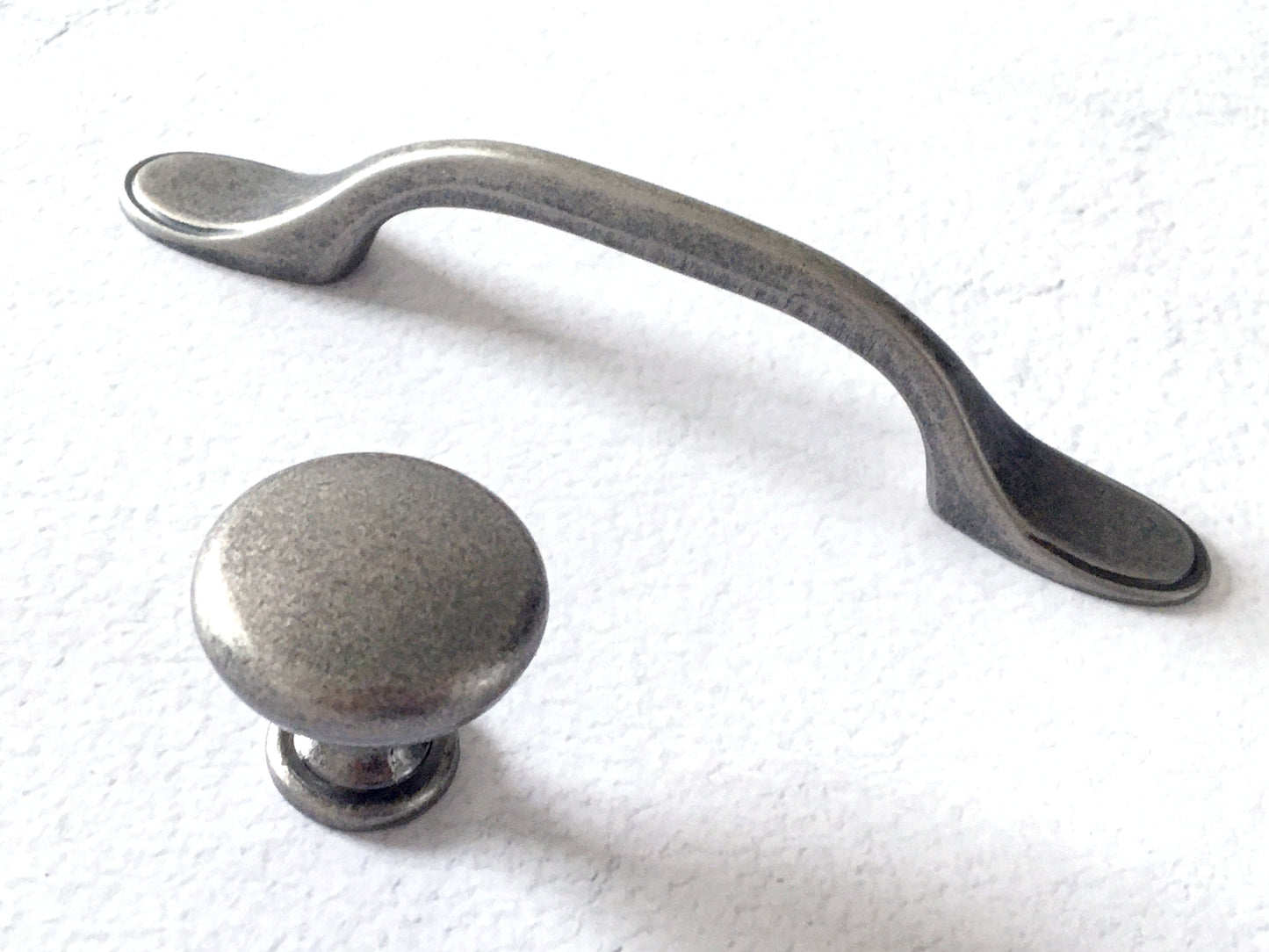 Pewter cabinet handle and knob on a white background