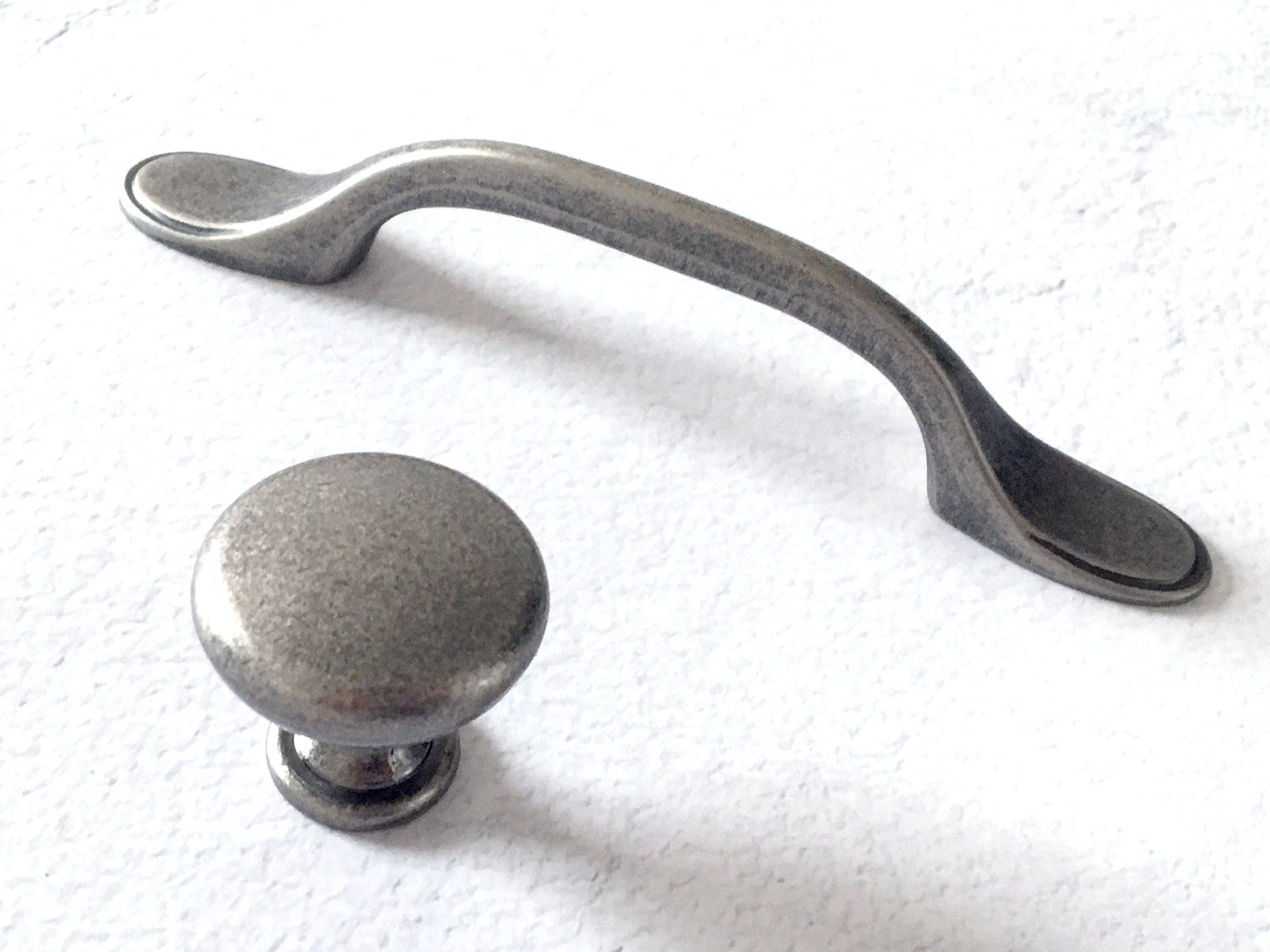Pewter cabinet handle and knob on a white background