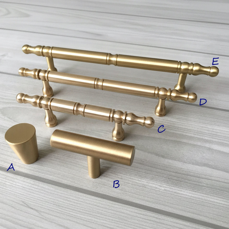 Set of gold cabinet handles on a light gray surface