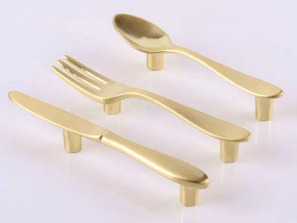 brushed brass fork/knife/spoon-shaped cabinet handles with 3-inch hole spacing