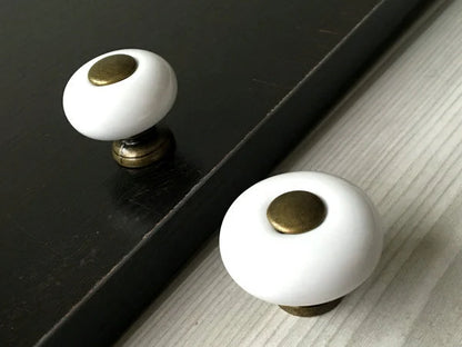Runder Schrankknopf aus weißer Keramik mit Metallmitte und -unterseite 