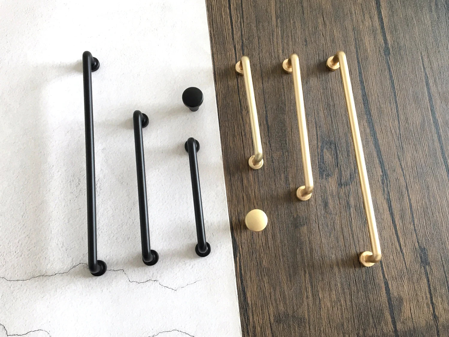 Set of black and gold cabinet bar handles on a wooden and white background