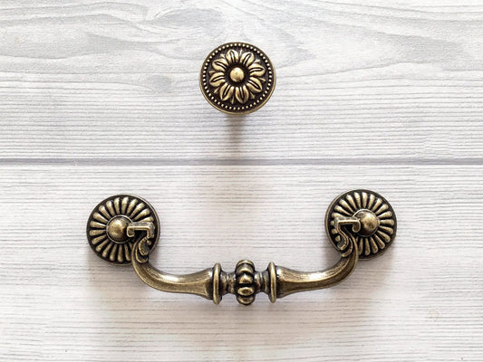 Retro Antique brass cabinet handle and knob set on a white textured background